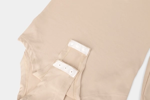 Macro shot of durable snap button closure on high elasticity nude bodysuit