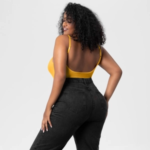 Detail view of bright yellow backless camisole bodysuit on a plus size model