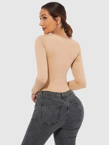 Detailed side view of nude long-sleeve bodysuit paired with charcoal skinny jeans