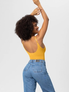 Detail showing the open back of a yellow seamless bodysuit and high waist denim jeans