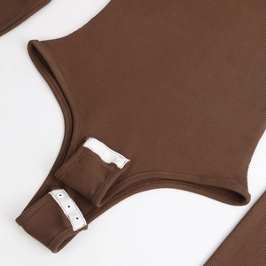 Vue macro détaillée des boutons-pression sur un body à manches longues côtelé marron
