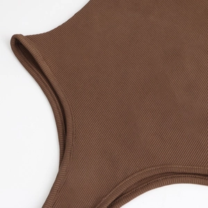 Gros plan du tissu en maille côtelée marron foncé montrant les coutures du body à manches