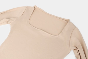 Detail of square neckline and shoulder stitching on beige long sleeve bodysuit