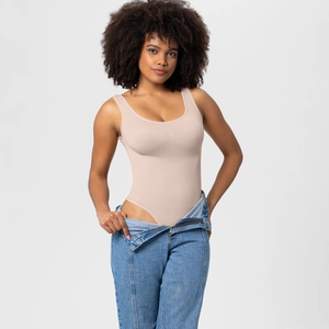 Close-up of nude seamless shaping bodysuit paired with light wash denim jeans