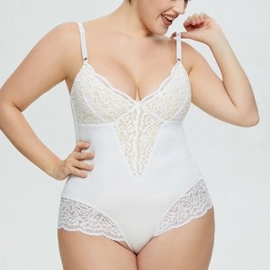 Close-up of intricate white lace embroidery and sheer mesh fabric on a deep V-neck bodysuit