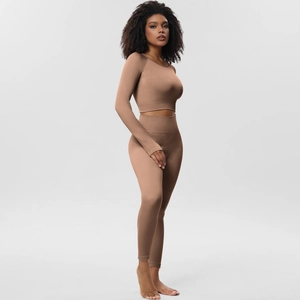 Detailed texture of seamless ribbed fabric on a tan long sleeve crop top and leggings