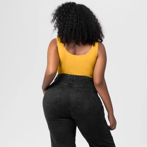 Rear view of seamless yellow bodysuit paired with high-waisted dark grey denim jeans
