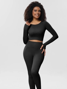 Close-up of black ribbed knit yoga set featuring thumbhole sleeves and high-waist leggings