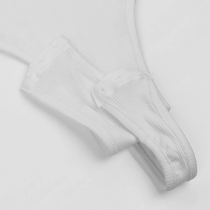 Close-up of white ribbed knit bodysuit showing the triple snap button crotch closure