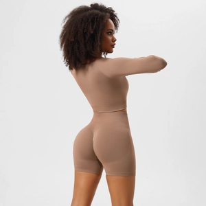 Detail of high-stretch seamless yoga set featuring long sleeve crop top and booty shorts