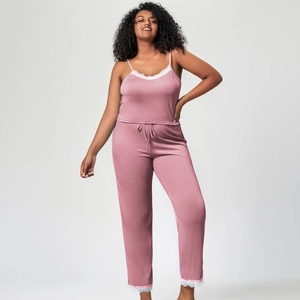 Détail du pyjama rose côtelé avec bordure en dentelle blanche sur le haut et le pantalon
