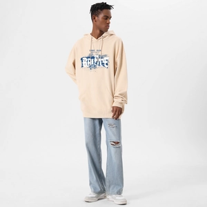 Detail of oversized beige hoodie with blue spray-paint Battle print and drop shoulders