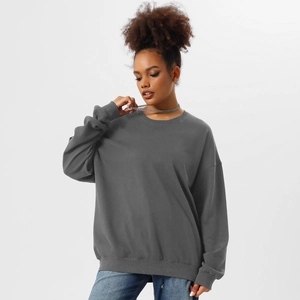 Detail of loose dark grey crewneck sweatshirt featuring ribbed cuffs and soft cotton texture