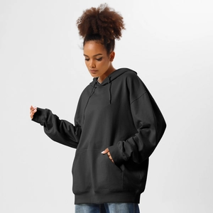 Detail of black oversized hoodie featuring drawstring hood, kangaroo pocket, and ribbed cuffs