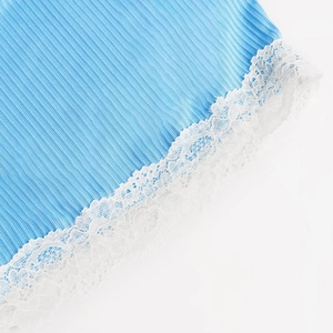 Gros plan détaillé du tissu en maille côtelée bleu clair avec bordure en dentelle blanche
