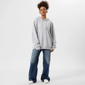 Detail view of heavy oversized grey hoodie paired with relaxed wide-leg blue jeans