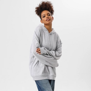 Detail of light grey oversized hoodie showing rib-knit cuffs and kangaroo pocket texture