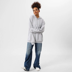 Full body studio shot of light grey oversized hoodie with wide-leg blue jeans and white shoes