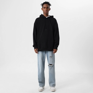 Macro view of oversized black hoodie showing premium cotton texture and kangaroo pocket