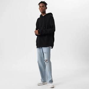 Detail of oversized black hoodie with kangaroo pocket and drawstring in a street style look