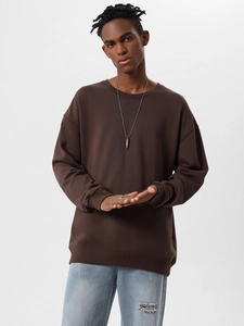 Detail of oversized dark brown cotton sweatshirt with dropped shoulder and relaxed fit design