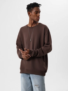 Detail view of a loose-fit dark brown crewneck sweatshirt featuring dropped shoulders design