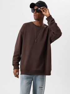 Detail of dark brown heavy cotton sweatshirt featuring ribbed collar and oversized fit