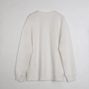 Detailed flat lay of a heavy white cotton sweatshirt featuring ribbed cuffs and hem