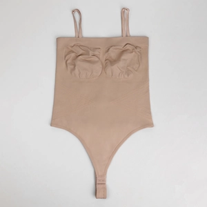 Detail view of seamless beige bodysuit with adjustable straps and abdominal compression