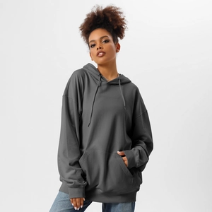 Detail of dark grey oversized hoodie featuring kangaroo pocket and ribbed cuffs