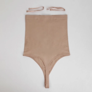 Detail view of seamless high-waist body shaper thong with ribbed tummy control texture