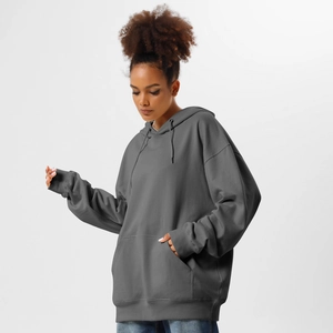 Detail of oversized dark grey hoodie showing kangaroo pocket and premium fabric texture