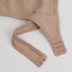 Detailed close-up of adjustable shoulder straps and three-row hook-eye closure in beige
