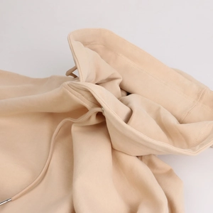 Detailed close-up of apricot hoodie neckline with premium metal-tipped drawstrings