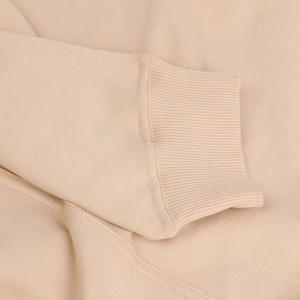 Close-up of ribbed cuffs and twill knit texture on premium beige oversized hoodie