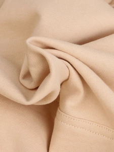 Texture detail of beige oversized hoodie showing premium cotton fabric and fine stitching