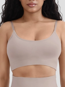 Close-up of seamless ribbed sports bra in lotus root color featuring removable pads