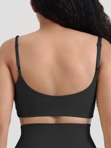 Detail of black seamless sports bra featuring a deep U-back design and thin straps