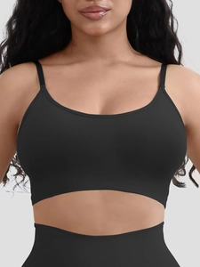 Detail of a black seamless crop top with deep U-neck and elastic ribbed hem for support