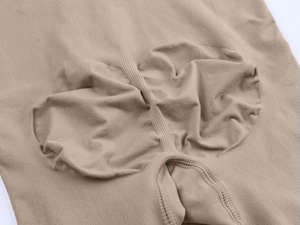 Close-up of seamless nude shapewear showing rib knit fabric and ruched butt lifting detail