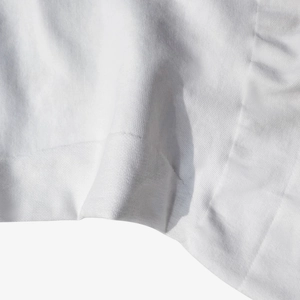 Macro detail of breathable white knitted fabric showing fine texture and soft cotton fibers