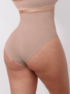 Detail of nude seamless high waist body shaper briefs showing elastic tummy control fabric