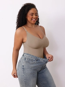 Detail of tan seamless shapewear bodysuit styled with denim jeans for a slimming effect