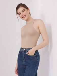 Detail of beige halter neck sleeveless shapewear bodysuit paired with blue jeans