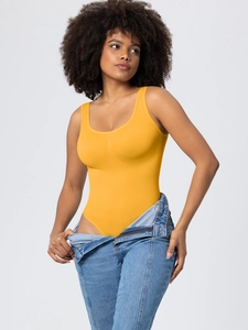 Slim fit ginger yellow sleeveless bodysuit for women paired with denim jeans for a stylish look