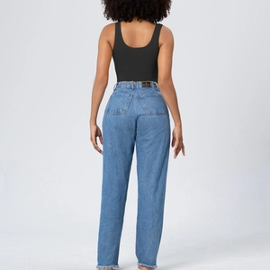 Rear view of black seamless bodysuit paired with high-waist jeans showing lift effect
