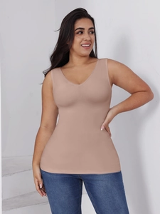 Detail view of seamless high-elastic V-neck body shaper vest in beige with denim jeans