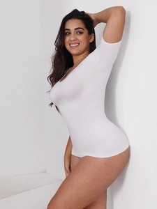 Détail du body blanc à manches courtes montrant le tissu extensible et la coupe sculptante
