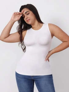 Slim fit white sleeveless round neck shaping top paired with blue jeans in a studio shot