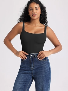 Dettaglio di un body nero senza maniche con scollo quadrato e jeans in denim blu